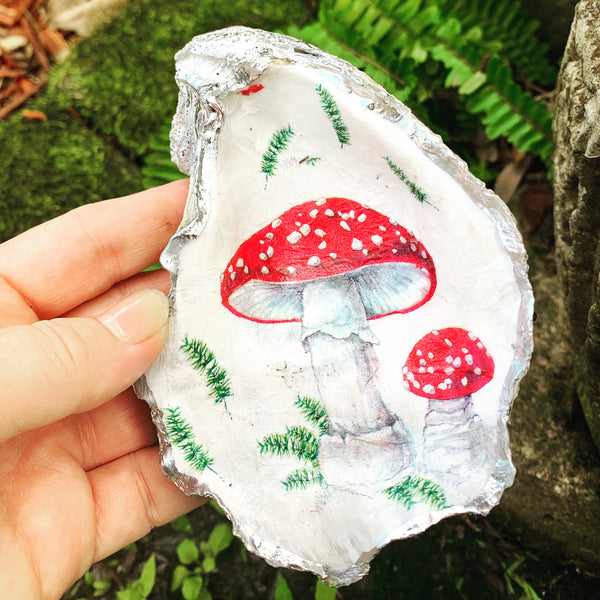red mushroom image decoupaged onto a large recylced oyster shell, trimmed  and painted on the back in metallic silver paint
