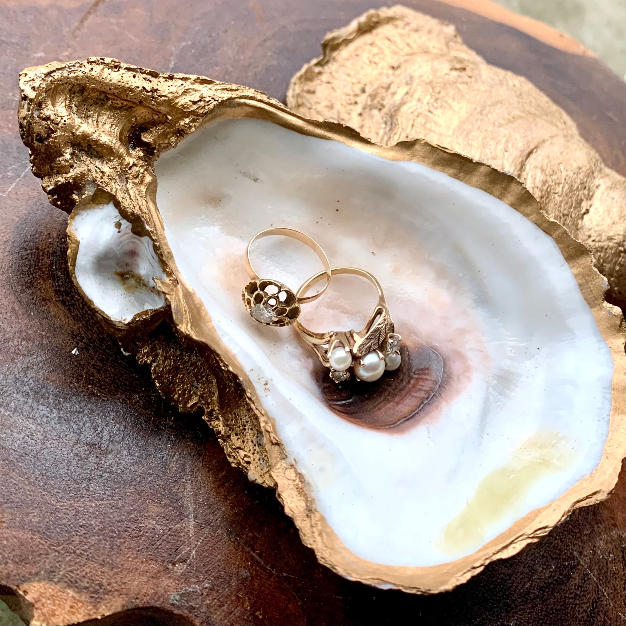 This oyster shell ring dish fatures beautiful recycled oyster shells from the gulf of mexico hand painted with metallic gold on the edges and back and covered in a a clear coat for shine and to highlight the pearly white color of the oyster shell. 
