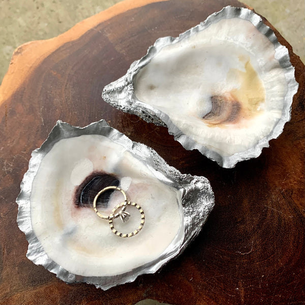 This oyster shell ring dish fatures beautiful recycled oyster shells from the gulf of mexico hand painted with metallic silver on the edges and back and covered in a a clear coat for shine and to highlight the pearly white color of the oyster shell. 